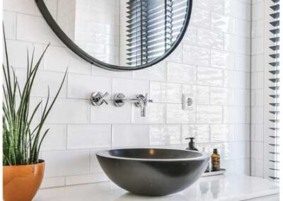 A modern bathroom featuring a sleek black bowl and a pristine white sink, showcasing a stylish contrast in design.